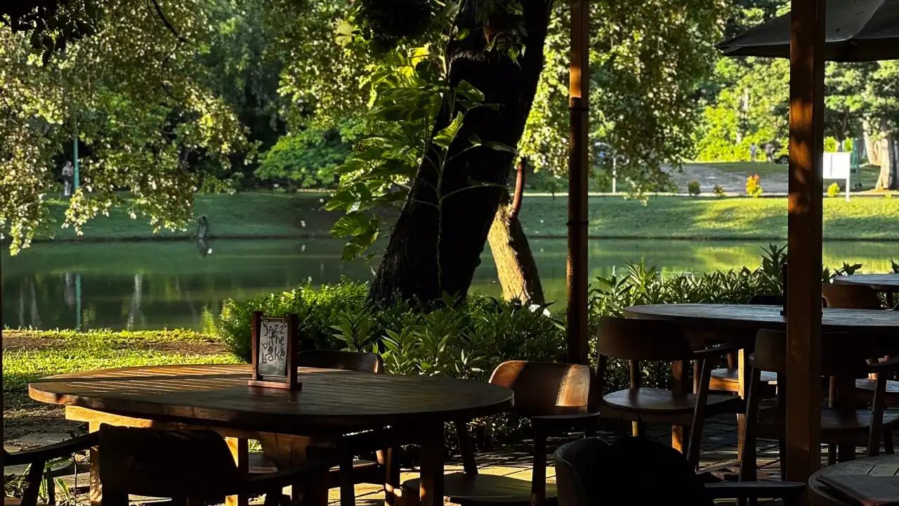 Teak tables under the timber canopy at Banyoo, looking out to the lake and the trees